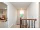 Upstairs hallway with natural light, wooden handrail, and view of room with window at 1914 Loggerhead Dr, Lancaster, SC 29720