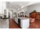 Open-concept kitchen with stainless steel appliances, granite counters, island with seating, and hardwood floors at 2021 Pinyon Ln, Lancaster, SC 29720