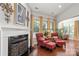 Living room featuring a fireplace, hardwood floors, and bright windows with decorative curtains at 2021 Pinyon Ln, Lancaster, SC 29720