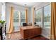 Well-lit office space with hardwood floors, a large desk, and several windows providing natural light at 2021 Pinyon Ln, Lancaster, SC 29720