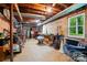 Unfinished basement used for storage with concrete walls, exposed pipes, and a small window at 2025 Sagamore Rd, Charlotte, NC 28209