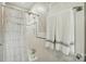 Full bathroom with white-tiled shower, a shower curtain, and a large door towel rack at 2025 Sagamore Rd, Charlotte, NC 28209