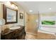 Bright bathroom features a vanity with a vessel sink, tub, and glass shower with tan tiling at 2025 Sagamore Rd, Charlotte, NC 28209