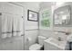 Well-lit bathroom features white tile, plantation shutters, and modern fixtures at 2025 Sagamore Rd, Charlotte, NC 28209