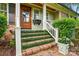 Close-up of a brick front porch with wooden door and decorative plants enhancing curb appeal at 2025 Sagamore Rd, Charlotte, NC 28209