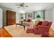 Bright living room with plush carpet, a ceiling fan, and ample seating, creating an inviting space at 2025 Sagamore Rd, Charlotte, NC 28209
