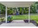 Backyard with a covered patio looking onto lush greenery, play set, and manicured garden beds at 204 Pebble Creek Xing, Fort Mill, SC 29715