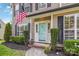 A close up view of the front door featuring a light blue door, an American flag, and manicured landscaping at 204 Pebble Creek Xing, Fort Mill, SC 29715
