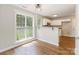 Bright kitchen area featuring hardwood floors, large windows, white cabinets, and an open layout at 204 Pebble Creek Xing, Fort Mill, SC 29715