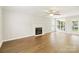 Well-lit living room featuring hardwood floors, a fireplace, large windows, and a ceiling fan at 204 Pebble Creek Xing, Fort Mill, SC 29715