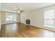 Bright living room with hardwood floors, a fireplace, large windows, a ceiling fan, and neutral wall colors at 204 Pebble Creek Xing, Fort Mill, SC 29715