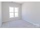Bright, empty bedroom featuring neutral walls and carpet, offering a blank canvas for personalization with a large window at 226 Gilead Rd, Huntersville, NC 28078
