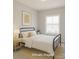 Cozy bedroom with natural light, featuring a black metal bed frame and neutral decor, creating a serene and inviting space at 226 Gilead Rd, Huntersville, NC 28078