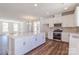 Well-lit kitchen with a center island, stainless steel appliances, and wood flooring at 226 Gilead Rd, Huntersville, NC 28078