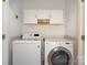 Bright laundry room featuring modern washer and dryer, with cabinets for storage at 2324 Bonterra Blvd, Indian Trail, NC 28079