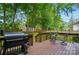 Back deck with a grill and a view of the treed backyard at 2426 Tory Oak Pl, Matthews, NC 28105