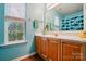 Bathroom with wood cabinets, white countertop, and window with natural light at 2426 Tory Oak Pl, Matthews, NC 28105