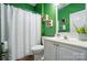 Well-maintained bathroom with a white vanity, shower, and bold green walls at 2426 Tory Oak Pl, Matthews, NC 28105