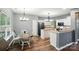 Eat-in kitchen with dining area offering chandelier lighting, stainless refrigerator, and wood-look flooring at 2426 Tory Oak Pl, Matthews, NC 28105