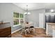 Bright dining area with views to the backyard, chandelier lighting, and wood-look flooring at 2426 Tory Oak Pl, Matthews, NC 28105