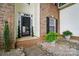 Inviting front entrance with a black screen door, brick accents, and potted greenery at 2426 Tory Oak Pl, Matthews, NC 28105