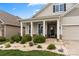 Inviting front porch with stone accents, white columns, seating area, and well-manicured landscaping at 274 Robinwood Ln, Lake Wylie, SC 29710
