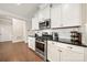 A bright kitchen featuring white cabinets, granite countertops, stainless steel appliances, and hardwood flooring at 274 Robinwood Ln, Lake Wylie, SC 29710