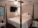 Cozy bedroom featuring a four-poster bed, ceiling fan, wood accents, and a mounted television at 2800 Patio Ln, Gastonia, NC 28056