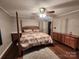 Traditional bedroom with wood floors, a four-poster bed, ceiling fan and dresser with ample storage at 2800 Patio Ln, Gastonia, NC 28056