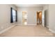 Neutral bedroom with tan carpet, window, and doors to other rooms within the house at 309 N Aspen St, Lincolnton, NC 28092