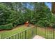 Serene backyard view featuring a play set, lush greenery, and a black metal fence at 310 Ridge Reserve Dr, Clover, SC 29710