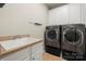 Well-equipped laundry room featuring a washer and dryer set, sink, cabinet storage, and a tiled floor at 310 Ridge Reserve Dr, Clover, SC 29710