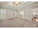 Spacious main bedroom with neutral carpet, trey ceiling, plantation shutters, and an open doorway to the main bathroom at 310 Ridge Reserve Dr, Clover, SC 29710