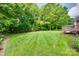 Large grassy backyard with a wooden deck and lush landscaping at 3741 Tea Olive Rd, Gastonia, NC 28056
