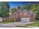 Brick home with a large driveway, well-kept lawn, and basketball hoop on a sunny day at 3741 Tea Olive Rd, Gastonia, NC 28056