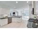 Open-concept kitchen with stainless steel appliances, black countertops, and a view into the living room at 3741 Tea Olive Rd, Gastonia, NC 28056