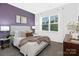 A cozy bedroom with a purple accent wall, a plush bed, and bright natural light from the window at 3940 Ashton Nw Dr, Conover, NC 28613