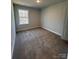 Bedroom with neutral walls, carpeted floors, white base trim, and a window that provides natural light at 4037 Port Richmond Ave # 8, Gastonia, NC 28056