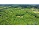 Aerial shot of a wooded lot with a home nestled among lush green trees at 4916 Leepers Creek Rd, Maiden, NC 28650