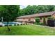 Backyard with a pool, patio, brick house, black fence, and garden plants at 4916 Leepers Creek Rd, Maiden, NC 28650
