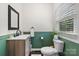 Charming half bathroom featuring green paneled walls and a modern vanity with a black framed mirror at 4916 Leepers Creek Rd, Maiden, NC 28650