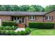Inviting front porch with rocking chairs, complemented by charming brick and lush landscaping at 4916 Leepers Creek Rd, Maiden, NC 28650