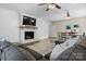 Bright living room showcasing fireplace with mounted TV, ceiling fans and view of dining area at 4916 Leepers Creek Rd, Maiden, NC 28650