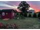 Charming backyard featuring a storage shed, garden, and lush lawn, set against a stunning sunset sky at 509 Brawley Rd # 7, Cleveland, NC 27013