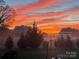 View of a picturesque backyard featuring lush greenery and trees bathed in the vibrant hues of the sunset at 509 Brawley Rd # 7, Cleveland, NC 27013