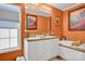 Bright bathroom with double sinks, white cabinets, a tub, and an orange accent wall at 509 Brawley Rd # 7, Cleveland, NC 27013