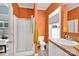 Bathroom featuring a shower, toilet, and vanity with warm orange walls and natural light at 509 Brawley Rd # 7, Cleveland, NC 27013