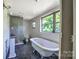 Bathroom featuring claw foot tub, shower, and a window offering abundant natural light at 5604 Nc 152 E Hwy, Rockwell, NC 28138