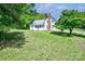 Charming two-story home featuring a brick chimney, metal roof, and lush green lawn with mature trees at 5604 Nc 152 E Hwy, Rockwell, NC 28138