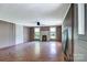 Spacious living room with fireplace, hardwood floors, large windows, and a ceiling fan at 5604 Nc 152 E Hwy, Rockwell, NC 28138